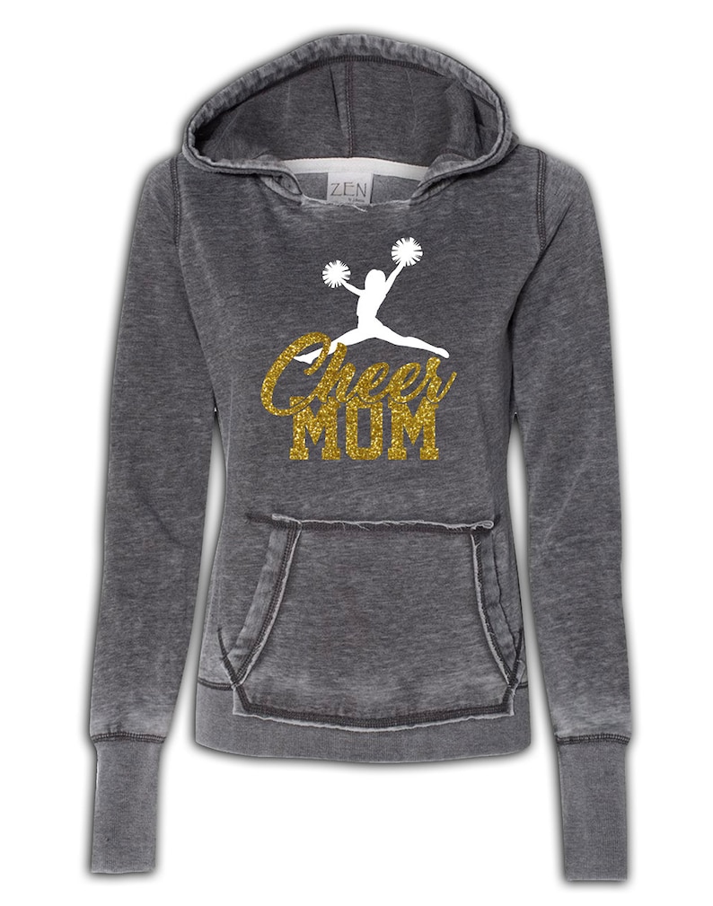 May include: Gray hooded sweatshirt with a white silhouette of a cheerleader and the text "Cheer Mom" in gold glitter.