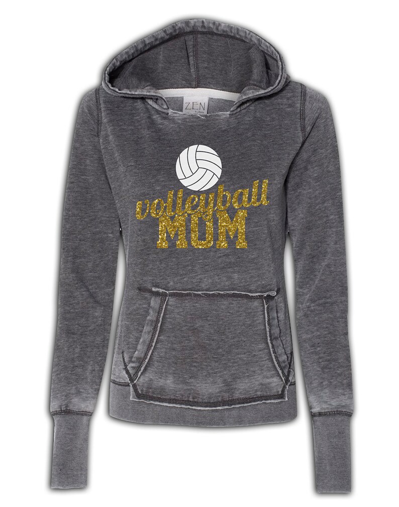 May include: Gray hooded sweatshirt with a distressed look. The sweatshirt has a white volleyball graphic and gold glitter text that reads "volleyball MOM".