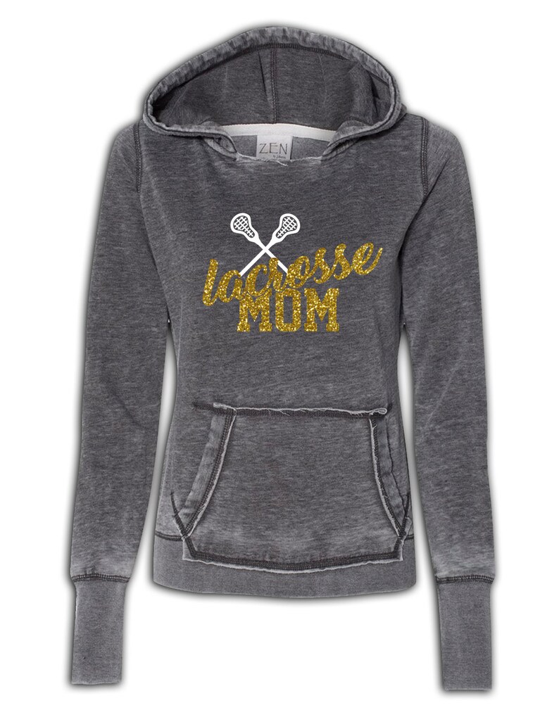 May include: A gray hooded sweatshirt with a distressed look. The front of the sweatshirt has a gold glitter design that says "lacrosse MOM" with two white lacrosse sticks crossed behind the text.