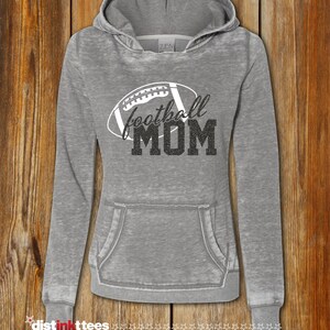May include: Gray hooded sweatshirt with a white football graphic and the text "football MOM" in black glitter.