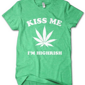 Könnte beinhalten: Grünes T-Shirt mit weißem Text "Kiss Me I'm Highrish" und einer weißen Marihuana-Blattgrafik.