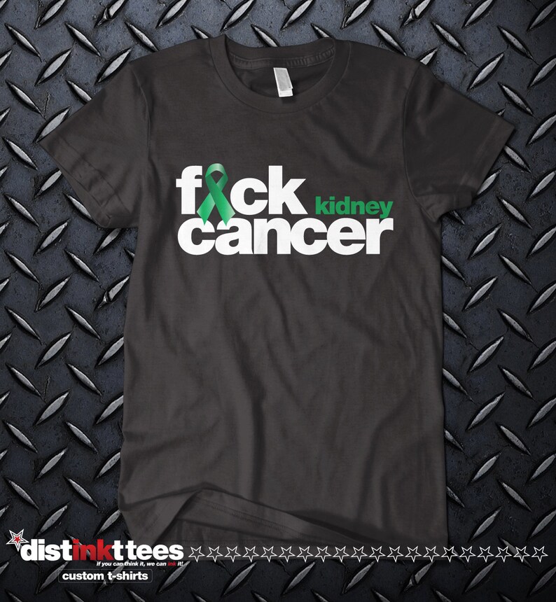 May include: Dark grey t-shirt with the text "f*ck cancer" in white, featuring a green ribbon replacing the "i" in "f*ck" and the word "kidney" in green. The shirt has a crew neck and short sleeves.