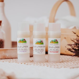 May include: Three white tubes of solid lotion with green and white labels. The labels read "Joyful Sounds Farm" and "Solid Lotion" with the scents "Lavender", "Sandalwood Vanilla", and "Peppermint".