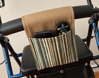 May include: A brown walker organizer with a striped pocket, holding a phone and remote control. The organizer is attached to a blue and black walker, providing convenient storage for essentials.