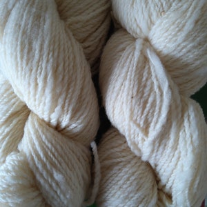 May include: Two skeins of white yarn, each skein is twisted into a figure eight shape.