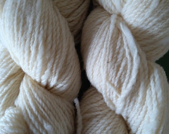 May include: Two skeins of white yarn, each skein is twisted into a figure eight shape.