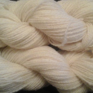 May include: A skein of off-white yarn, a soft and fluffy natural fiber, perfect for knitting or crocheting.
