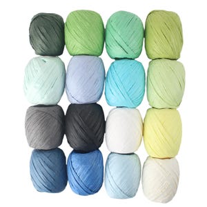 May include: A collection of sixteen spools of raffia ribbon in various colors, including shades of green, blue, gray, and yellow. The spools are tightly wound and arranged in a grid pattern, perfect for crafting and gift wrapping.