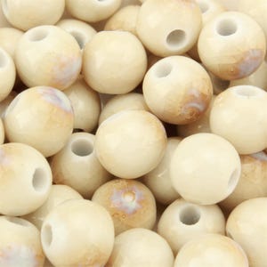 May include: A collection of round, off-white beads featuring a subtle crackled texture and a glossy finish. Each bead has a central hole and displays faint, warm-toned brown marbling patterns across the surface, creating a uniform appearance.