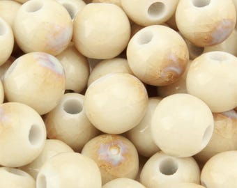 May include: A collection of round, off-white beads featuring a subtle crackled texture and a glossy finish. Each bead has a central hole and displays faint, warm-toned brown marbling patterns across the surface, creating a uniform appearance.