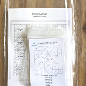 May include: A quilting pattern titled "Starry Sampler" in a clear plastic sleeve. The pattern includes diagrams of quilt blocks and instructions. The overall size is 50.00 by 50.00 inches. The block diagram is labeled "TJ's Starry Sampler - Block 1".