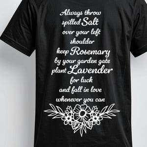 May include: A black short-sleeved t-shirt featuring white text that reads: Always throw spilled Salt over your left shoulder, keep Rosemary by your garden gate, plant Lavender for luck, and fall in love whenever you can, with a floral graphic below.