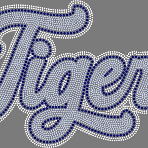 Può includere: Un design a trasferimento di strass che raffigura la parola Tigers in un carattere corsivo. La scritta è composta da strass azzurri con un contorno in strass blu scuro e un bordo in strass bianco su uno sfondo grigio.