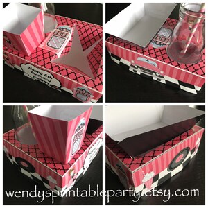 Könnte beinhalten: Eine rosa und schwarze Party-Geschenkbox mit einem Jukebox-Design. Die Box hat einen Platz für eine Flasche, eine Tasse und einen kleinen Leckerbissen. Die Box ist mit einem karierten Muster und den Worten "Happy 6th Birthday Audrey" verziert.