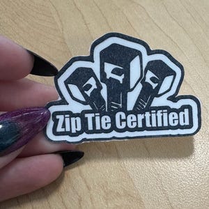 May include: Black and white sticker with three zip ties and the text "Zip Tie Certified".