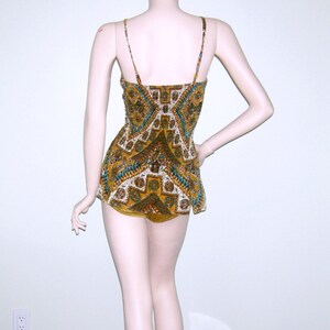 May include: A brown and green patterned swimsuit with a geometric design. The swimsuit has thin straps and a fitted bodice.