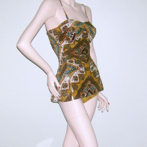 May include: A vintage swimsuit with a geometric pattern in shades of brown, gold, and teal. The swimsuit has a fitted bodice and a full skirt.