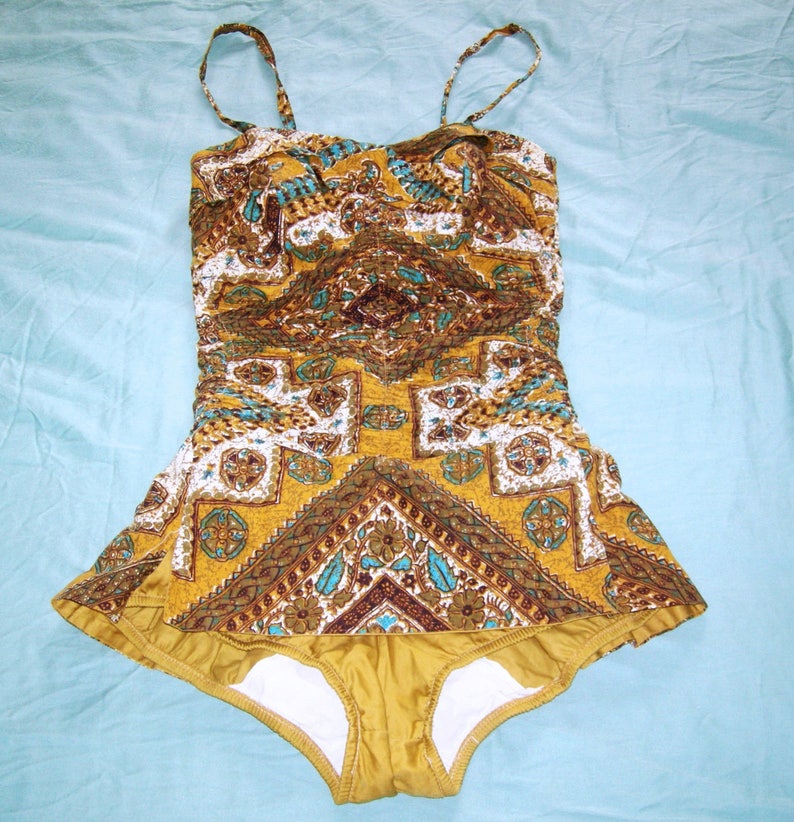 May include: A vintage yellow and brown patterned swimsuit with a halter top and a ruffled skirt.