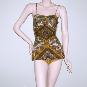 May include: A vintage swimsuit with a geometric pattern in shades of brown, gold, and turquoise. The swimsuit has a halter top and a high-waisted bottom.