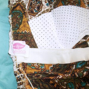 May include: A brown and white patterned fabric with a white mesh panel and a pink label that says "Berrybrooke 34" and "Made in U.S.A."