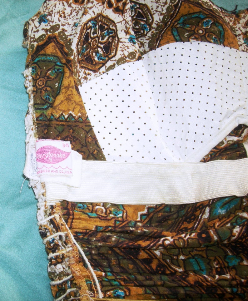 May include: A brown and white patterned fabric with a white mesh panel and a pink label that says "Berrybrooke 34" and "Made in U.S.A."