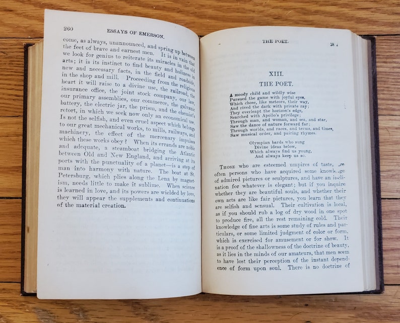 May include: An open book with a yellowed page, showing an excerpt from "Essays of Emerson" and "The Poet" from the book "The Complete Works of Ralph Waldo Emerson". The text discusses the nature of poetry and the poet's role in society.