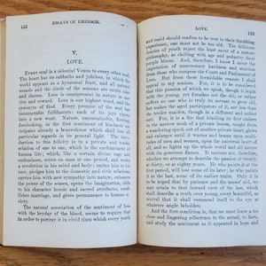 May include: An open book with yellowed pages, showing an excerpt from an essay on love by Ralph Waldo Emerson. The text discusses the nature of love and its evolution throughout life.