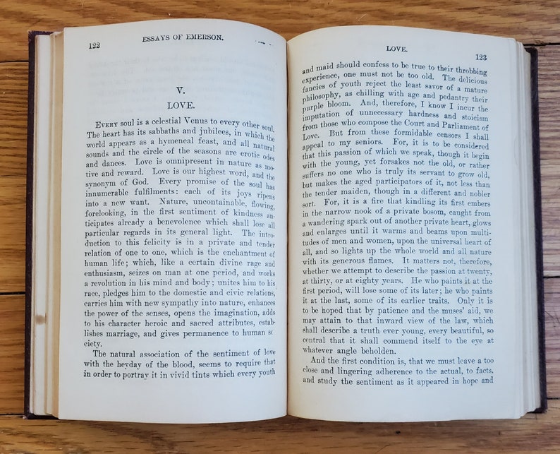 May include: An open book with yellowed pages, showing an excerpt from an essay on love by Ralph Waldo Emerson. The text discusses the nature of love and its evolution throughout life.