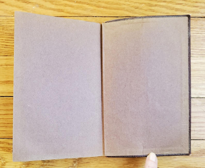 May include: A brown leather-bound book with a blank cover. The book is open to reveal blank pages.