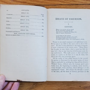 May include: An open book with a white background and black text. The book is titled "Essays of Emerson" and the first essay is titled "History". The text discusses the concept of a universal mind that is shared by all individuals.