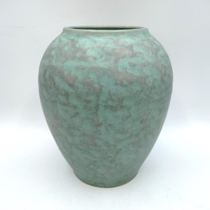 May include: A large, round ceramic vase with a wide opening. The vase has a mottled teal and gray finish. The surface has a textured appearance. The vase is a decorative item for the home.