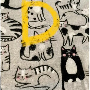 May include: A gray fabric with a repeating pattern of black and white cats. The cats are in various poses, including sitting, lying down, and standing. One cat is highlighted with a yellow circle.