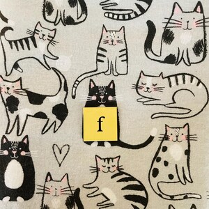 Pode incluir: Um tecido cinza e branco com um padr&atilde;o repetido de gatos pretos e brancos. Os gatos est&atilde;o em v&aacute;rias poses, incluindo sentados, deitados e em p&eacute;. O tecido tem uma textura sutil e um fundo cinza claro.