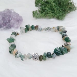 May include: A green agate chip bracelet with a silver leaf charm. The bracelet is made of natural stones and is a beautiful and unique piece of jewellery.