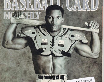 May include: A black and white photo of a baseball player wearing a chest protector and holding a bat. The photo is from the June 1990 issue of Beckett Baseball Card Monthly. The text "The Ad Agency" is in the bottom right corner of the image.