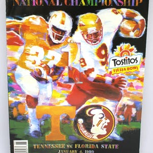May include: A magazine cover featuring a football game. The cover has the words "NATIONAL CHAMPIONSHIP" in rainbow colors at the top. Two football players are in action. The Tostitos Fiesta Bowl logo is visible. The text reads "TENNESSEE vs. FLORIDA STATE JANUARY 4, 1999".