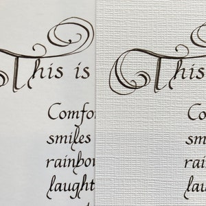 May include: A close-up of a handwritten note that reads "This is comfort, smiles, rainbows, laughter, sunsets, hugs and..." The note is written in black ink on white paper with a textured surface.