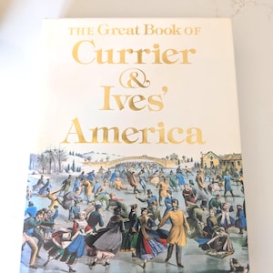 May include: A hardcover book titled "The Great Book of Currier & Ives' America" with gold lettering on a cream background. The cover features a colorful illustration of people ice skating on a frozen lake.