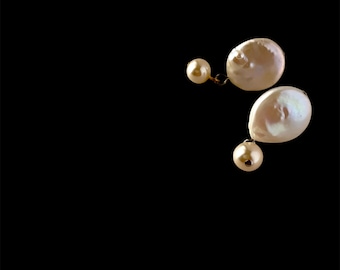 May include: A pair of pearl earrings with a drop design. The earrings are made of white pearls and gold metal.