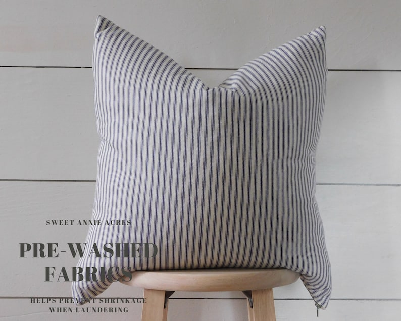 May include: A white and blue striped pillow with the text "Sweet Annie Acres Pre-Washed Fabrics Helps Prevent Shrinkage When Laundering" on the front.