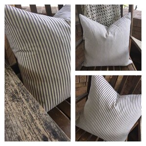 May include: Three striped pillows with a white background and thin navy blue stripes. The pillows are shown on a wooden chair and a wooden bench.