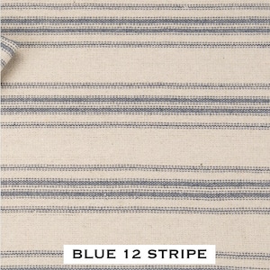 May include: A close-up of a white fabric with blue stripes. The fabric has a woven texture and the stripes are evenly spaced. The text "BLUE 12 STRIPE" is printed at the bottom of the image.