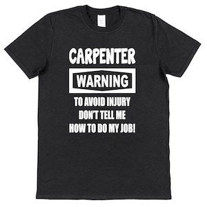 May include: Black t-shirt with white text that reads "Carpenter Warning To Avoid Injury Don't Tell Me How To Do My Job!"