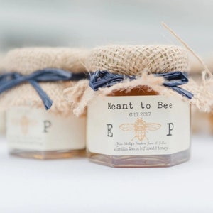 1.5oz hexagon honey favor featured in Southern Living magazine. The topper is a Natural Burlap with a Pearl Navy Raffia Ribbon. The label is in Ivory and our Vintage Bee Monogram Initial Design (font is in a Vintage Typewriter style.)
