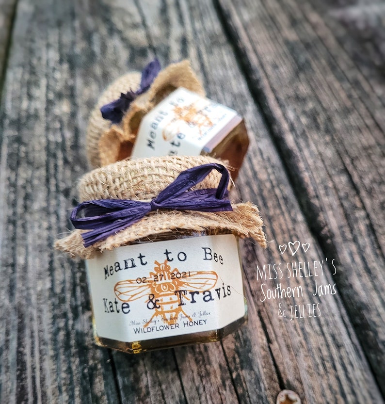 1.5oz Hexagon honey favor with Natural Burlap and a Navy raffia ribbon. The label design is our Vintage Bee with a Vintage Typewriter font done on an Ivory label color.