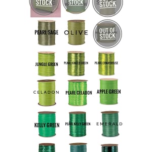 May include: A collection of spools of green ribbon in various shades, including jungle green, pearl celadon, and emerald. The spools are labeled with the ribbon color names.