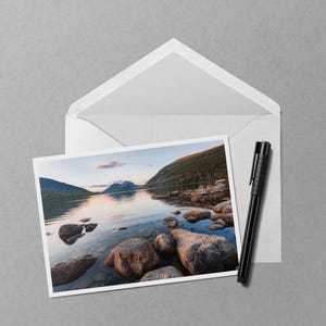 May include: A set of three ceramic mugs with a speckled, matte finish. The mugs are in shades of cream, light gray, and dark gray. Each mug has a simple, minimalist design and a rounded handle.