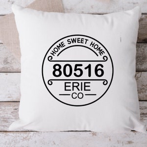 May include: White pillow with a black and white graphic that says "Home Sweet Home" with the zip code "80516" and "Erie CO" underneath.
