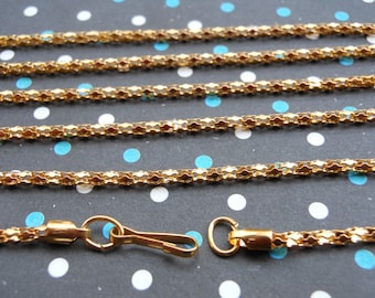May include: Gold chain with a lobster clasp. The chain is made of small, linked squares.