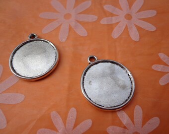 May include: Two silver-toned round metal pendant charms with a smooth, slightly textured surface. The charms have a hole at the top for attaching to a chain or cord.
